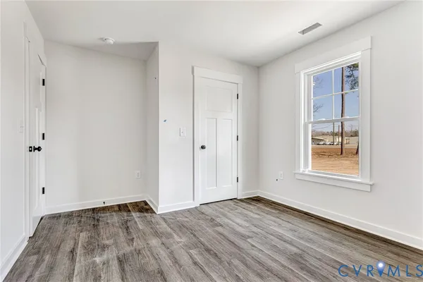 a view of a room with wooden floor and window