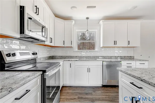 a kitchen with stainless steel appliances granite countertop a sink stove and cabinets