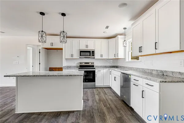 a kitchen with stainless steel appliances granite countertop a stove a sink dishwasher a refrigerator and white cabinets with wooden floor