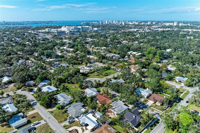 an aerial view of residential houses with outdoor space and trees