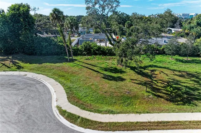 an aerial view of residential houses with outdoor space and trees
