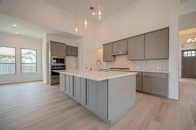 a kitchen with a sink cabinets and wooden floor