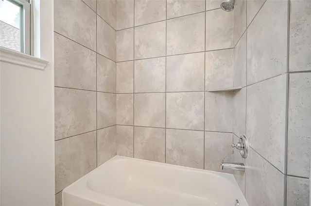 a bathroom with a white bath tub and a shower