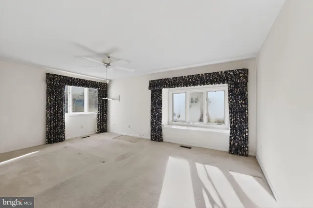 a view of an empty room with a fireplace and a window