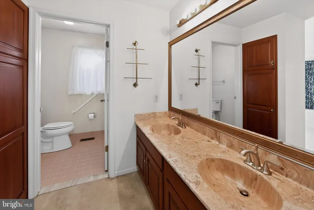 a spacious bathroom with a granite countertop sink a toilet and shower