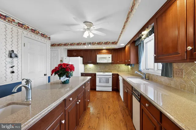a kitchen with kitchen island granite countertop a sink cabinets and stainless steel appliances