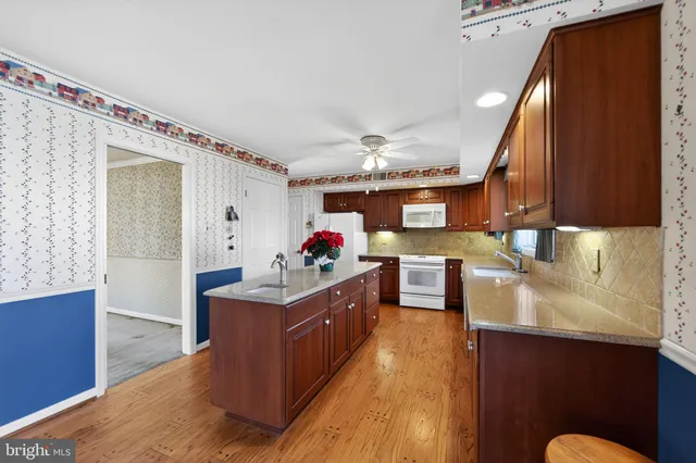 a kitchen with stainless steel appliances granite countertop a sink stove and wooden cabinets