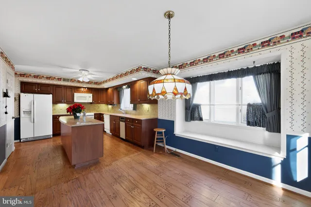a kitchen view with a wooden floor and a view of living room
