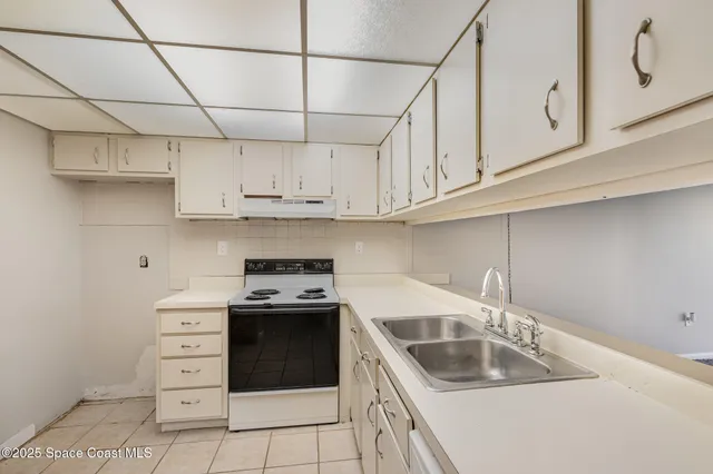 a kitchen with stainless steel appliances granite countertop a sink stove and white cabinets