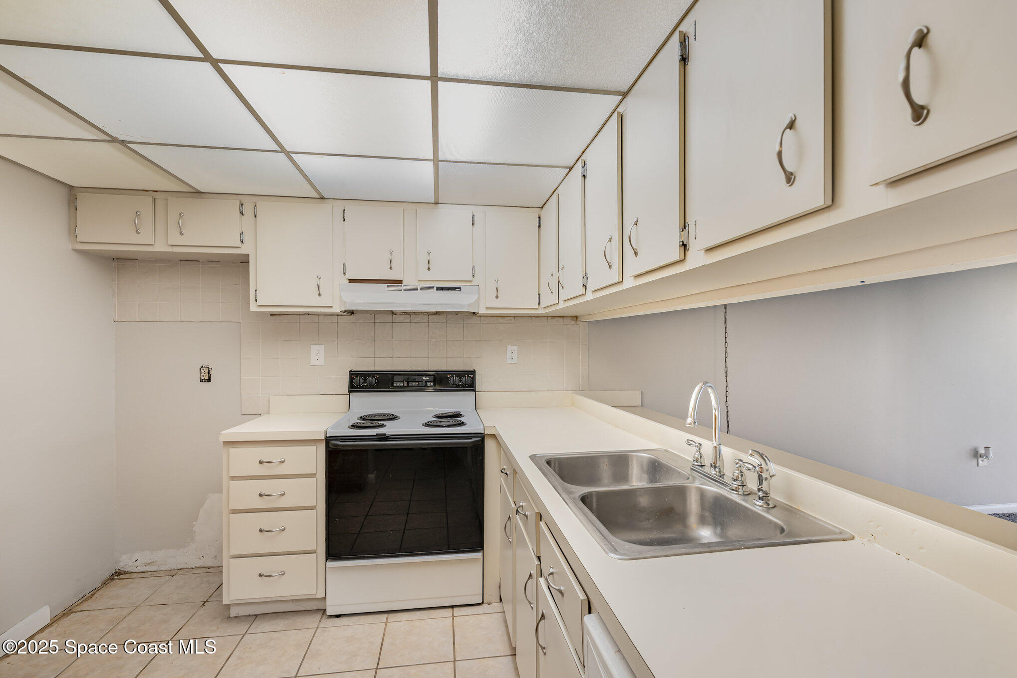 2727 North Wickham Road, Unit 10210 Melbourne, FL 32935 - Photo 11 of 35 a kitchen with stainless steel appliances granite countertop a sink stove and white cabinets