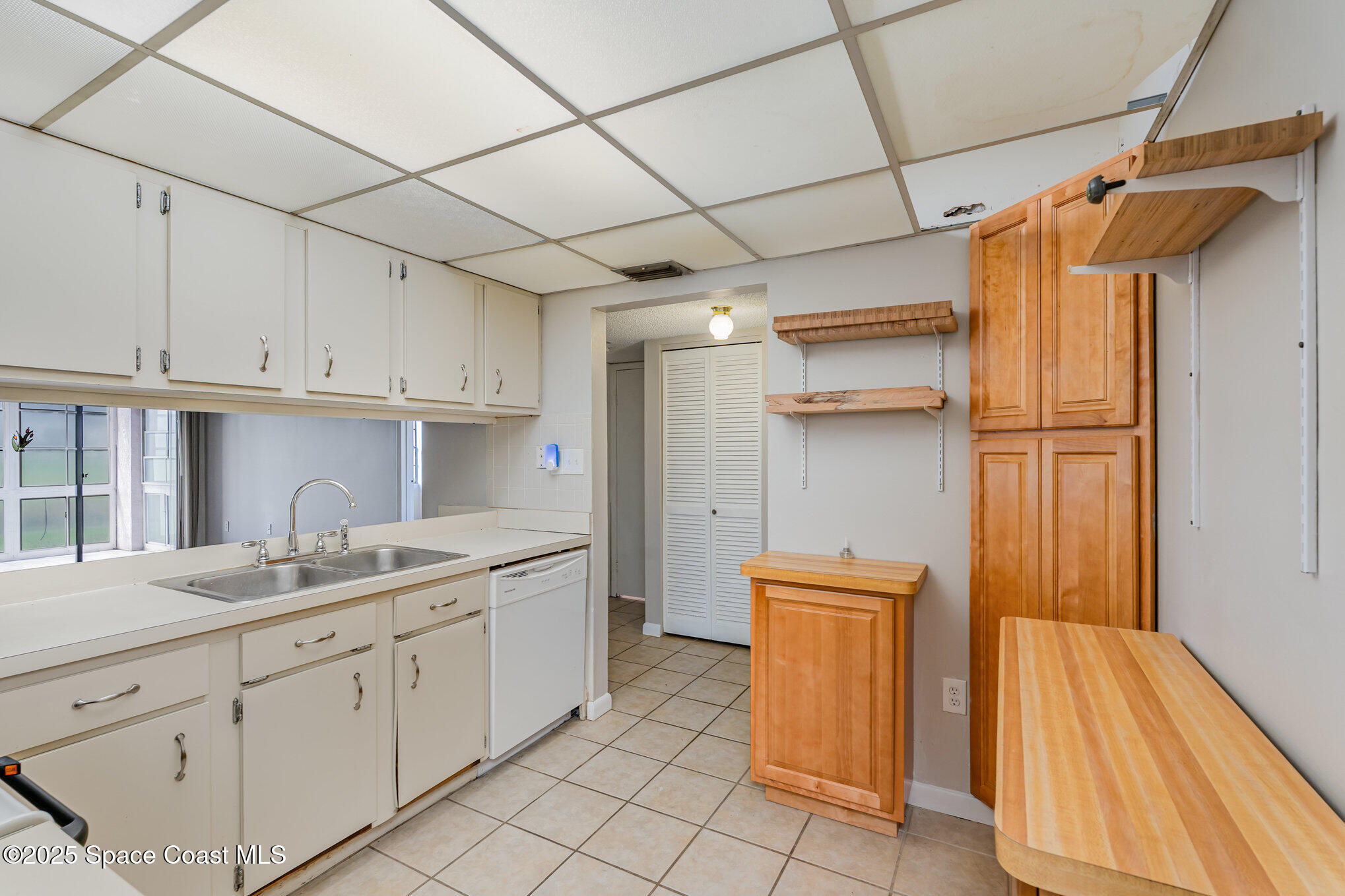 2727 North Wickham Road, Unit 10210 Melbourne, FL 32935 - Photo 12 of 35 a kitchen with a sink and wooden cabinets