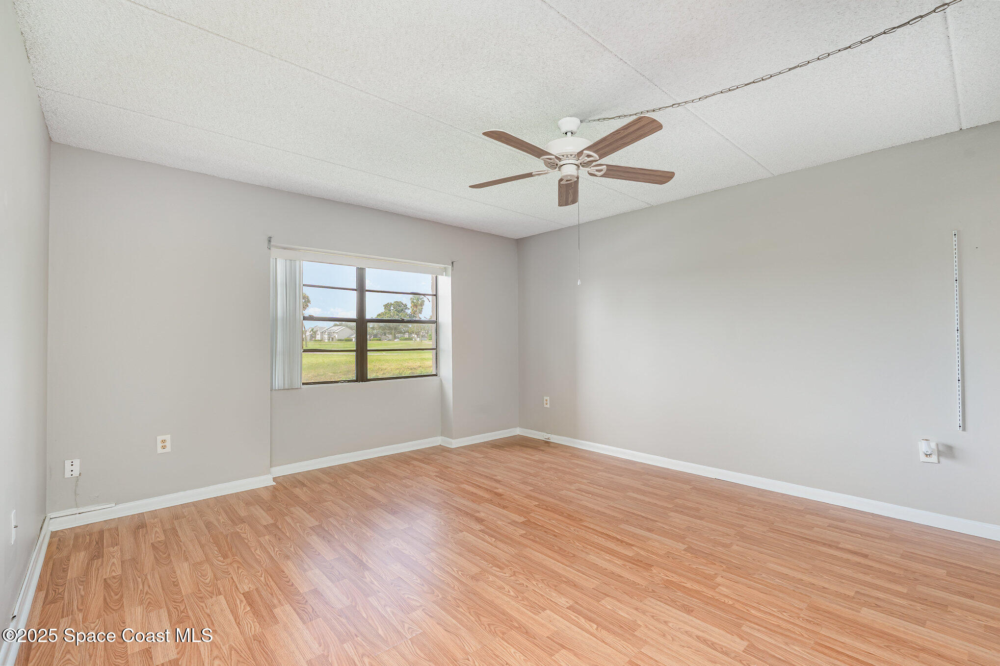 2727 North Wickham Road, Unit 10210 Melbourne, FL 32935 - Photo 14 of 35 a view of empty room with wooden floor and fan