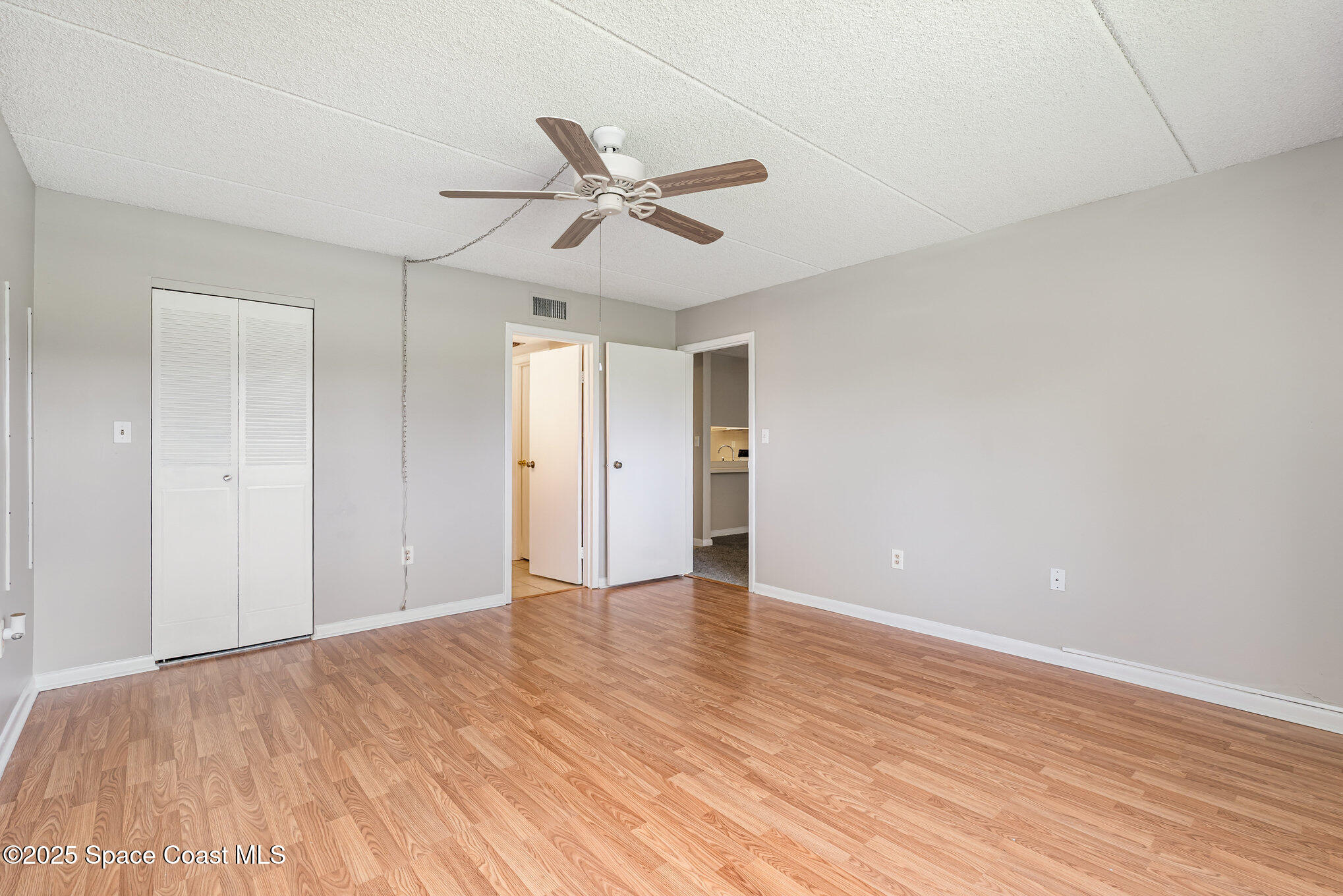 2727 North Wickham Road, Unit 10210 Melbourne, FL 32935 - Photo 16 of 35 a view of an empty room and wooden floor