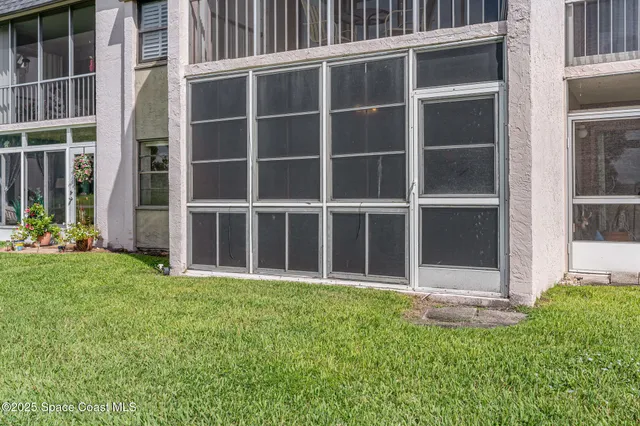 a view of a backyard with potted plants and large window