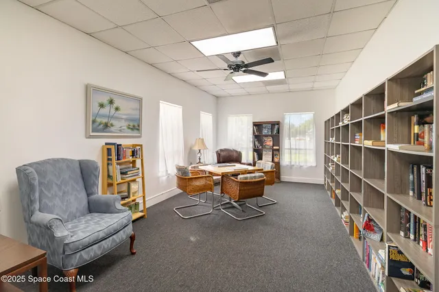 a living room with furniture a rug and a book shelf