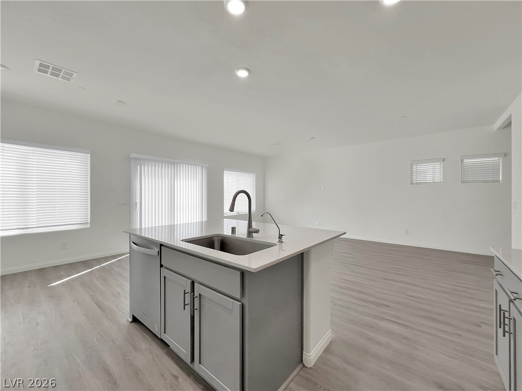 9984 Indigo Cliffs Street Las Vegas, NV 89141 - Photo 31 of 31 Kitchen featuring visible vents, a sink, open floor plan, gray cabinets, and stainless steel dishwasher