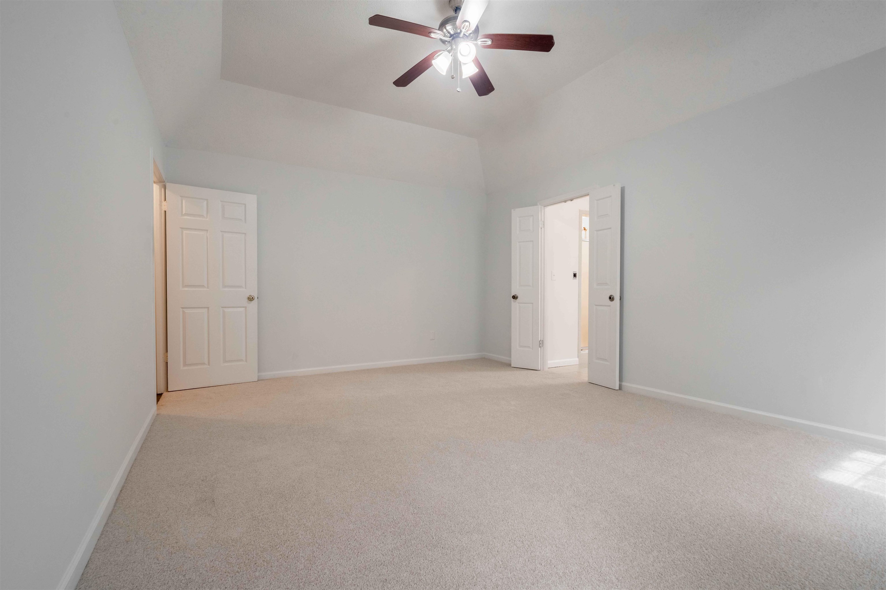 7800 Buck Ridge Cove Memphis, TN 38016 - Photo 22 of 36 Spacious room featuring vaulted ceilings, light gray wall paint, and light-toned carpet flooring