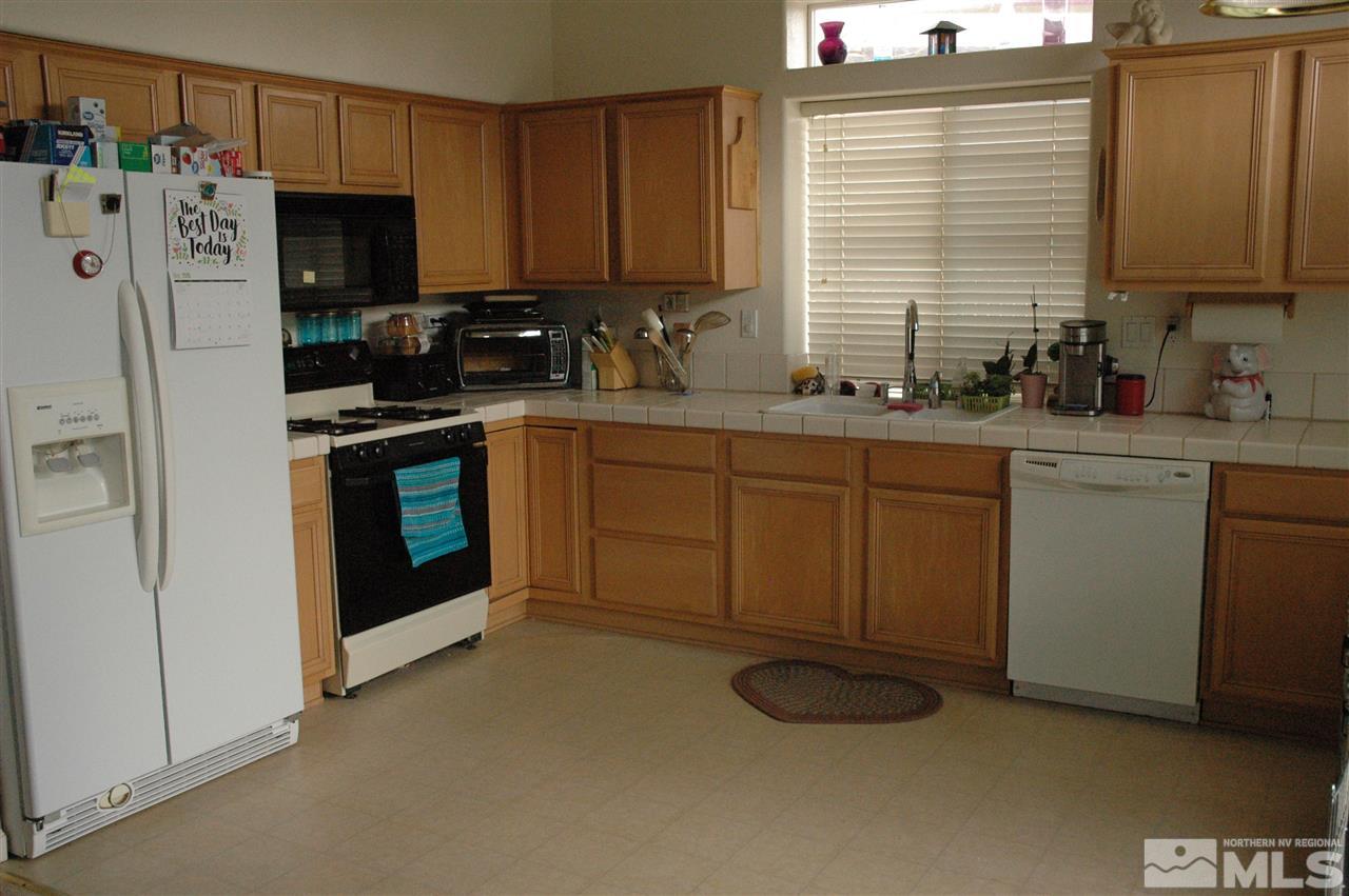 14661 Gold Run Drive Reno, NV 89521 - Photo 4 of 12 a kitchen with stainless steel appliances granite countertop a stove a sink dishwasher and a refrigerator