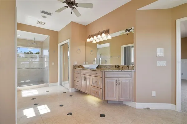 a spacious bathroom with a granite countertop sink mirror and shower