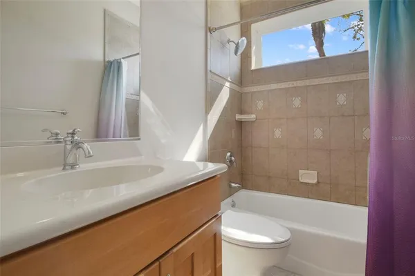 a bathroom with a granite countertop sink a toilet and shower