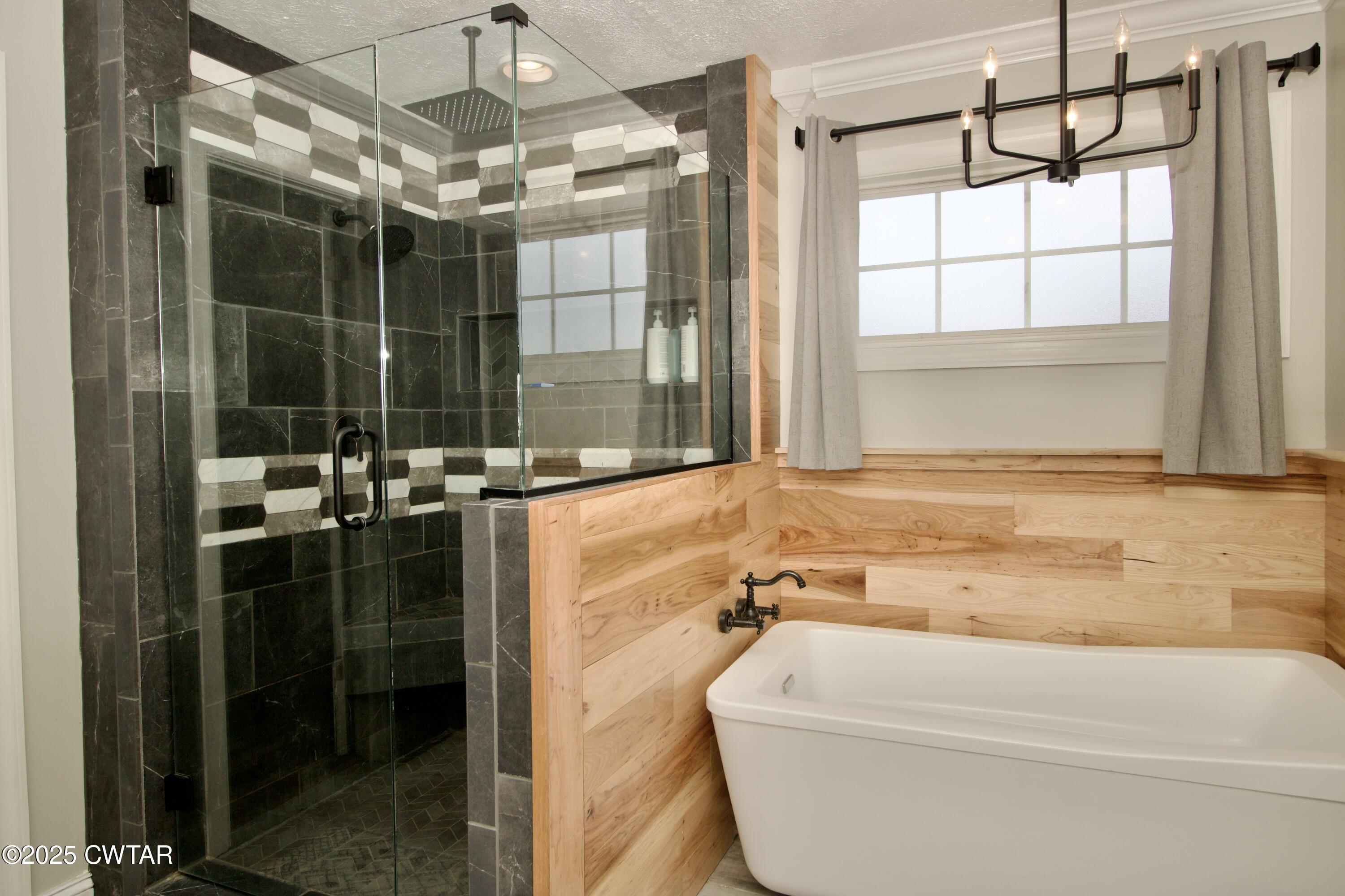 177 Fawn Ridge Lane Medina, TN 38355 - Photo 17 of 44 a bathroom with a tub a window and a glass door shower