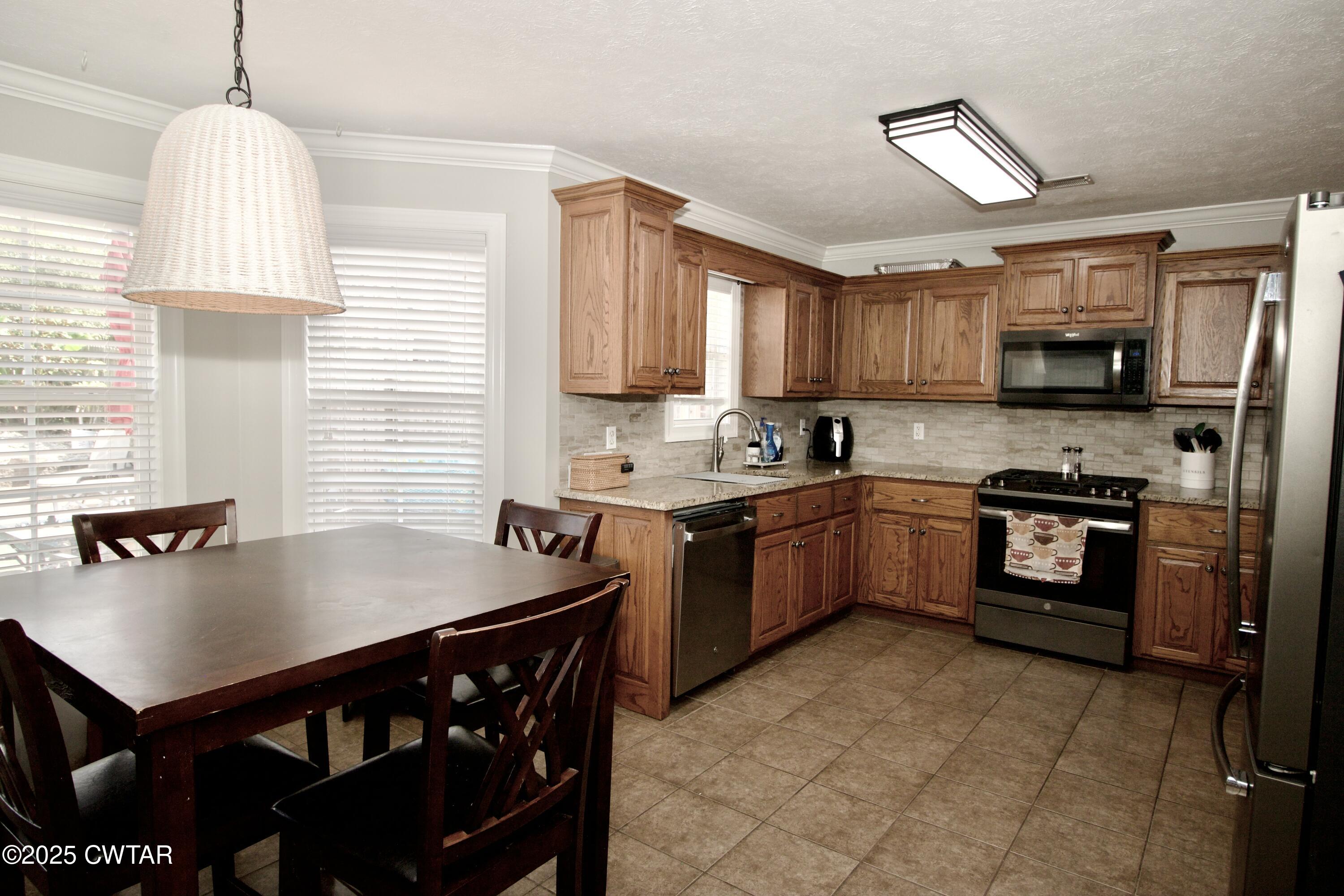 177 Fawn Ridge Lane Medina, TN 38355 - Photo 32 of 44 a kitchen with stainless steel appliances granite countertop a sink stove window and refrigerator