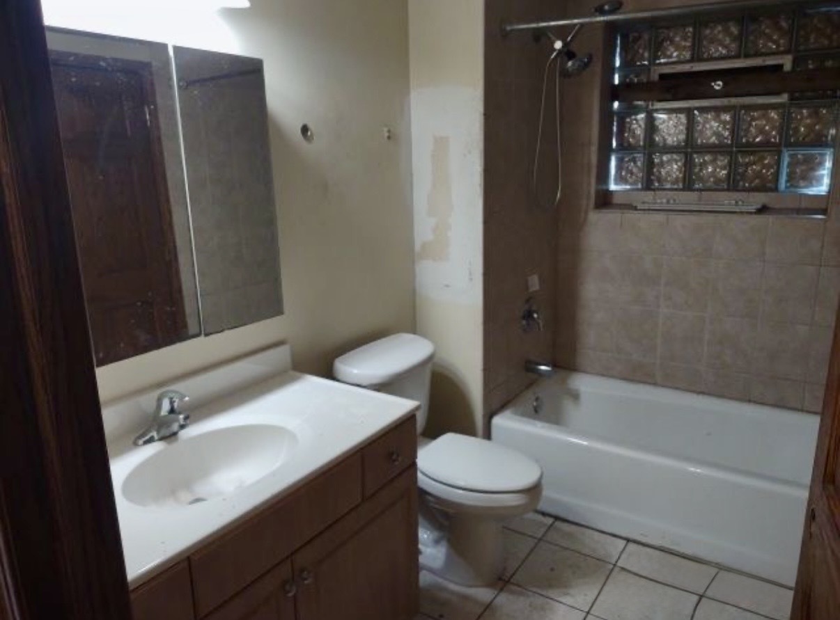 9356 South Oglesby Avenue Chicago, IL 60617 - Photo 7 of 12 a bathroom with a sink toilet and shower