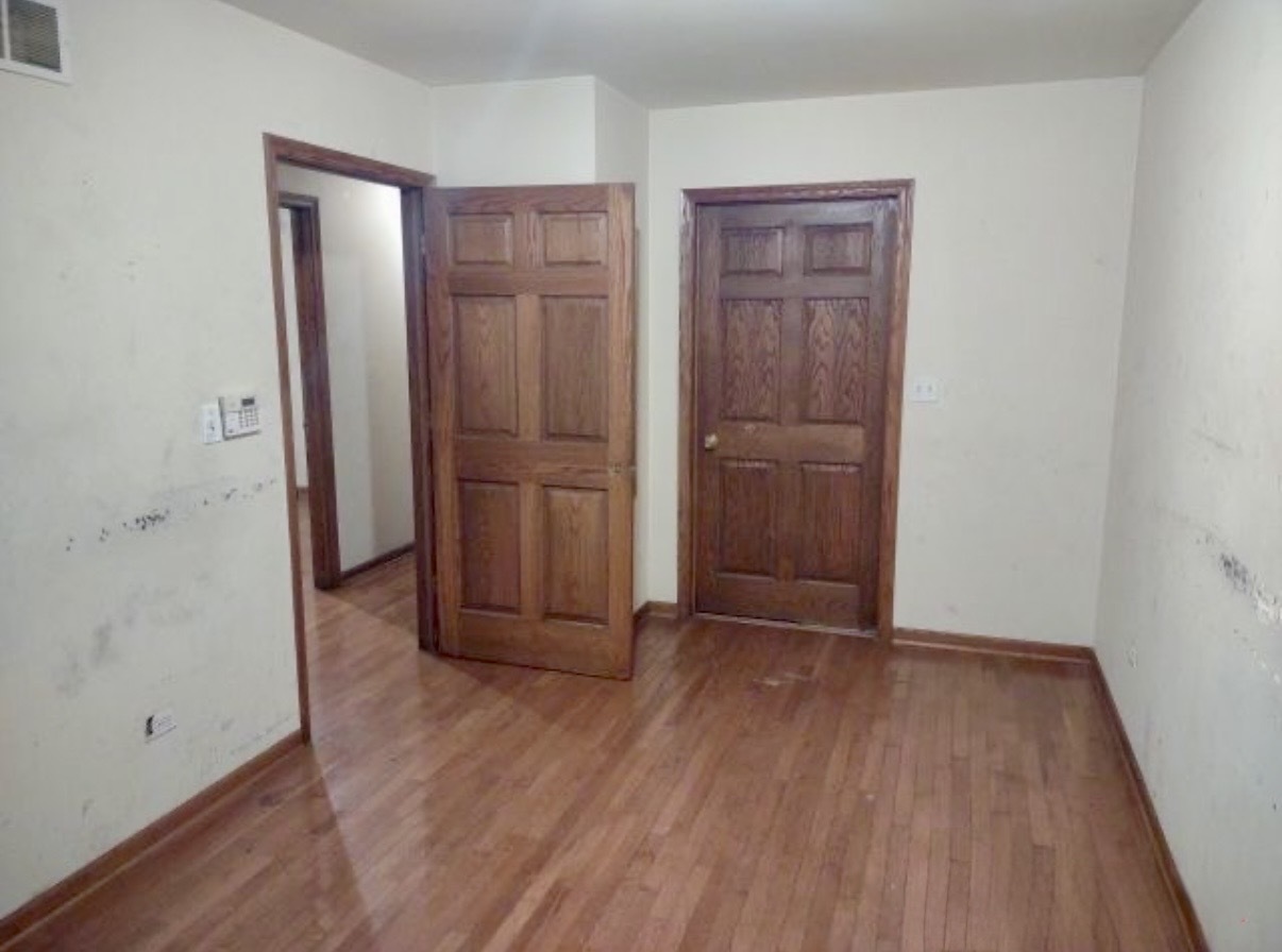 9356 South Oglesby Avenue Chicago, IL 60617 - Photo 9 of 12 an empty room with wooden floor and closet