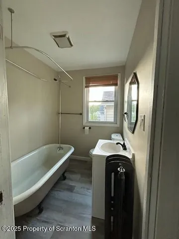 a bathroom with a tub sink and mirror