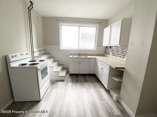 a kitchen with a white stove top oven sink and window