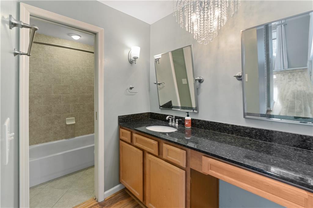 1468 Briarwood Road Northeast, Unit 1104 Atlanta, GA 30319 - Photo 13 of 15 a bathroom with a granite countertop sink and a mirror