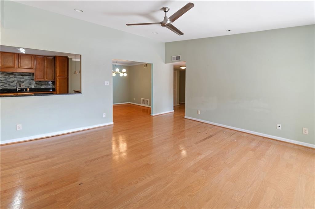 1468 Briarwood Road Northeast, Unit 1104 Atlanta, GA 30319 - Photo 2 of 15 an empty room with wooden floor and a ceiling fan