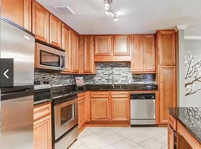 a kitchen with stainless steel appliances granite countertop a stove sink and cabinets