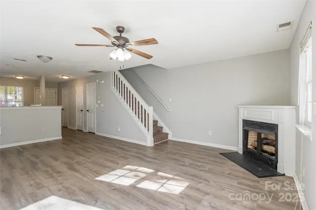 a view of an empty room with a fireplace and a window