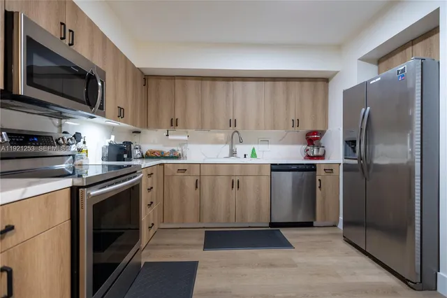a kitchen with a sink a refrigerator and cabinets