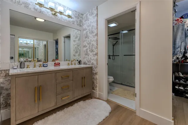 a bathroom with a double vanity sink mirror and shower