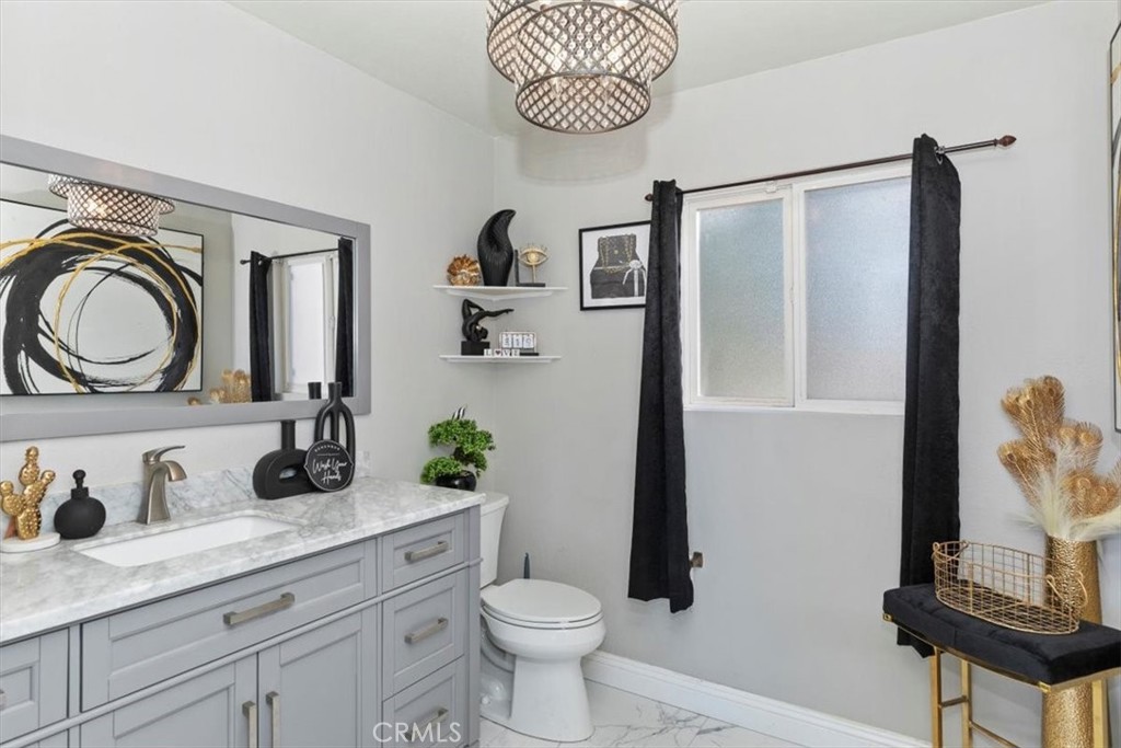 1619 Gratton Street Riverside, CA 92504 - Photo 32 of 62 a bathroom with a granite countertop sink a toilet and a mirror