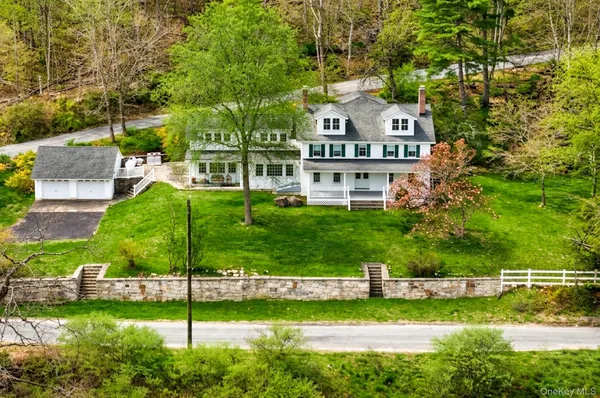 a view of a white house with a big yard and large trees