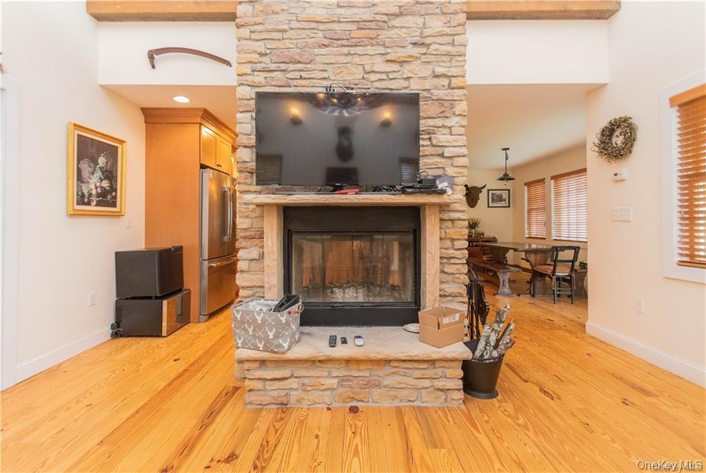 669 Mountain Road Bloomingburg, NY 12721 - Photo 13 of 36 Detailed view of a stone fireplace, freestanding refrigerator, and wood finished floors