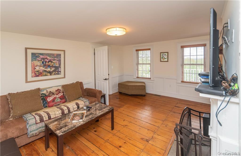 669 Mountain Road Bloomingburg, NY 12721 - Photo 16 of 36 Living room with light wood finished floors and wainscoting
