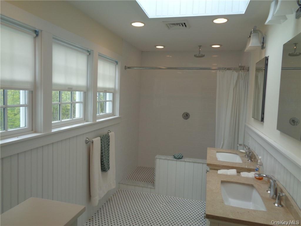669 Mountain Road Bloomingburg, NY 12721 - Photo 27 of 36 Full bathroom with a walk in shower, radiator heating unit, double vanity, wainscoting, and recessed lighting