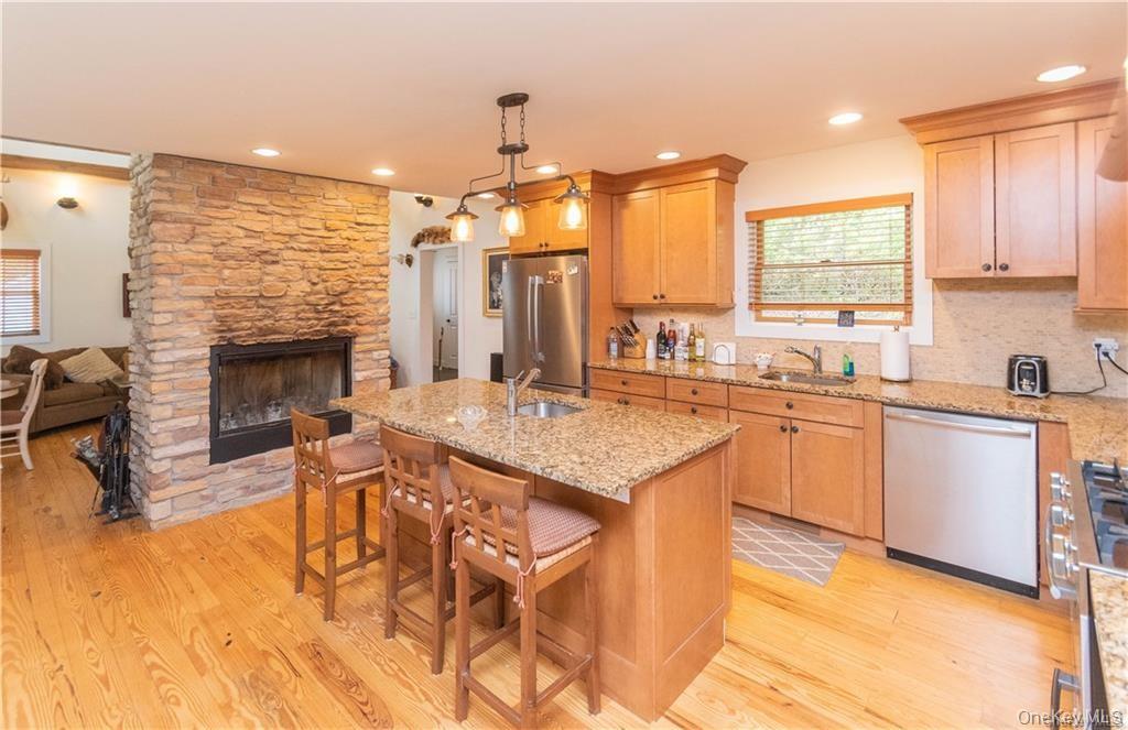 669 Mountain Road Bloomingburg, NY 12721 - Photo 36 of 36 Kitchen with stainless steel appliances, a breakfast bar, a center island with sink, open floor plan, and light stone counters
