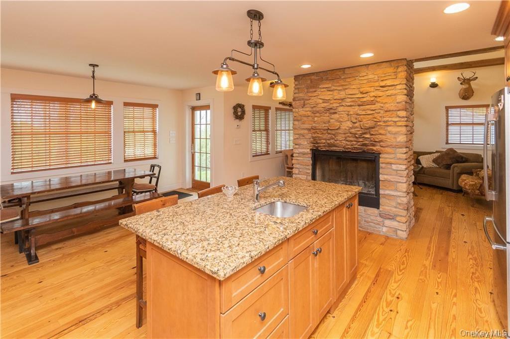 669 Mountain Road Bloomingburg, NY 12721 - Photo 8 of 36 Kitchen with a breakfast bar, pendant lighting, an island with sink, light stone counters, and light wood-style floors