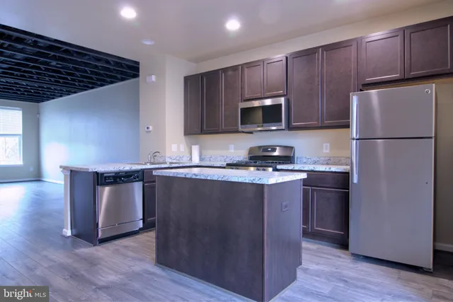 a kitchen with granite countertop wooden cabinets a sink and dishwasher