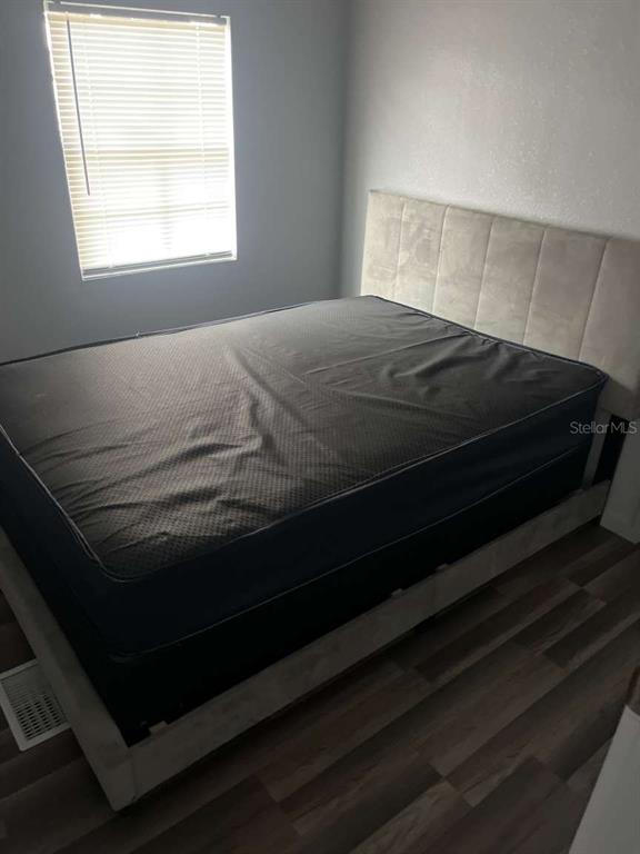 1511 Gaines Road Winter Haven, FL 33880 - Photo 13 of 20 a bedroom with a bed wooden floor and window