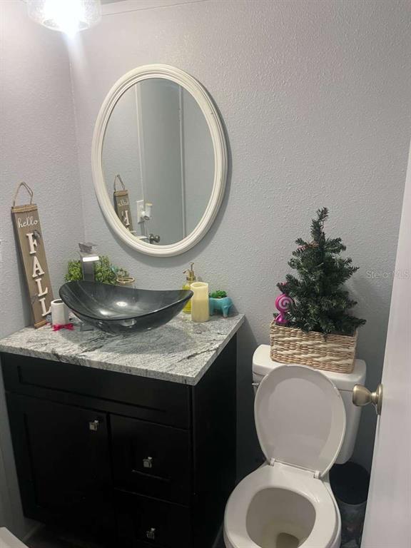 1511 Gaines Road Winter Haven, FL 33880 - Photo 3 of 20 a bathroom with a granite countertop toilet and a sink