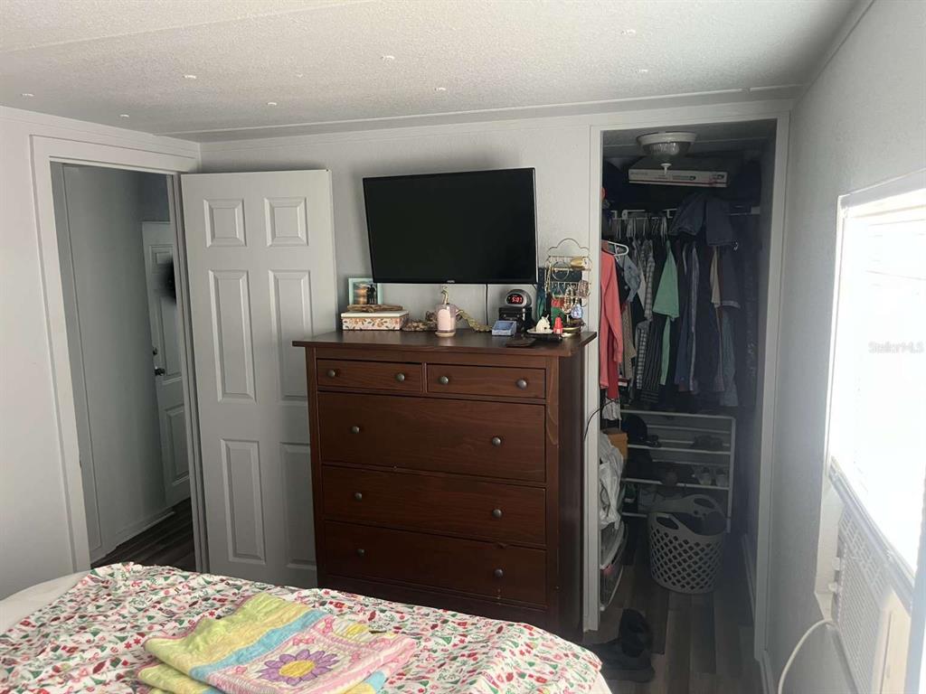 1511 Gaines Road Winter Haven, FL 33880 - Photo 9 of 20 a bedroom with a bed and a flat tv screen on dresser