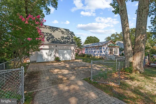 a front view of a house with a garden and lake view