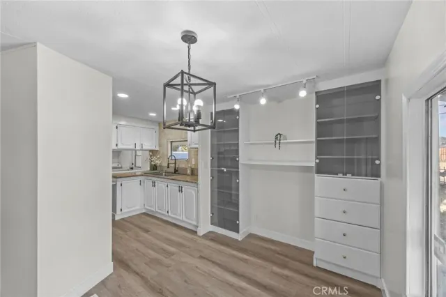 a kitchen with a refrigerator and white cabinets