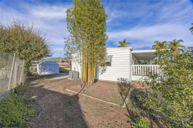 a front view of a house with a garden and lake view